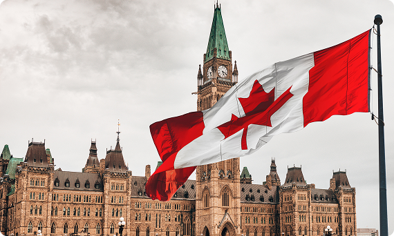 Canadian flag flying in front of the Parliament buildings in Ottawa